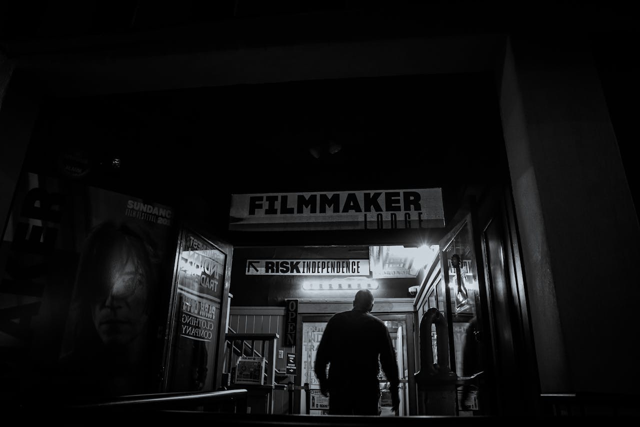 An individual enters a filmmaker-themed building at night, evoking a mysterious artistic vibe.